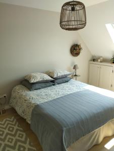 a bedroom with a bed with a blue comforter at Le Clos des Mouettes in Calais