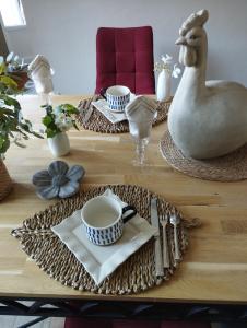 a table with plates and cups and a chicken on it at Le Clos des Mouettes in Calais