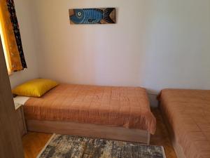 a bedroom with two beds and a painting on the wall at App Oljka in Karigador