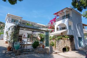 a large white building with a stone wall at Odyssey Suites in Poros