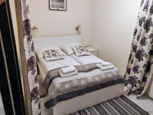 niewielka sypialnia z łóżkiem i zasłonami w obiekcie Enklawa Mielno przy plaży - Szklane apartamenty w mieście Mielno