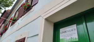un panneau sur le côté d'un bâtiment avec une fenêtre dans l'établissement Lindenhaus, à Sibiu