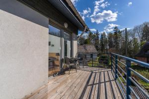 una terraza de madera con mesa y sillas. en VäeVilla en Otepää