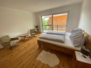 - une chambre avec un lit et une grande fenêtre dans l'établissement Appartmens am Attersee Dachsteinblick, à Nussdorf am Attersee