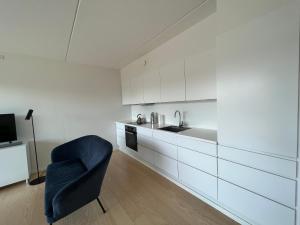 a kitchen with a blue chair and a sink at Copenhagen centre luxury apartment - Østerbro in Copenhagen