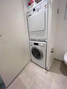 a washer and dryer in a small bathroom at Copenhagen centre luxury apartment - Østerbro in Copenhagen