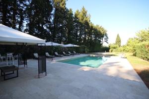 einen Pool mit Stühlen und Sonnenschirmen neben in der Unterkunft Magnifique Gîte en provence in Sarrians