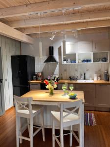 uma cozinha com uma mesa de madeira e 2 cadeiras em Lille Bornholm em Banie Mazurskie