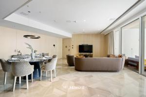 a dining room and living room with a table and chairs at Manzil - Lavish 2BR Sea View Apartment in Five Palm, Palm Jumeirah in Dubai