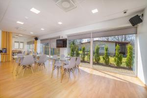 une salle à manger avec une table, des chaises et une grande fenêtre dans l'établissement VäeVilla, à Otepää