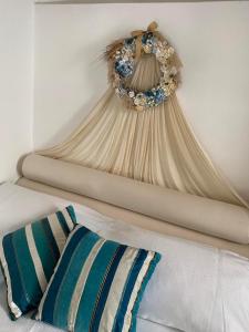 a wreath hanging on a wall next to a bed at Vera's traditional house - Chora in Serifos Chora