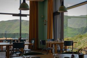 a restaurant with tables and chairs and a large window at Gudauri Lodge in Gudauri