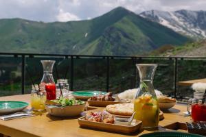 uma mesa com comida com montanhas ao fundo em Gudauri Lodge em Gudauri