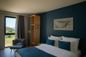 a bedroom with a bed and a chair and a window at Gudauri Lodge in Gudauri