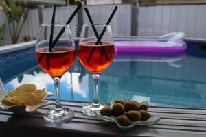 サン・チェザーリオ・ディ・レッチェにあるCamera di Luna Primeのスイミングプールのそばでのワイン2杯