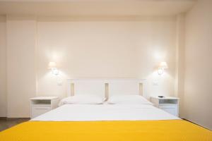a bedroom with a large white bed with yellow blanket at Residence O'Sole Mio Pompei in Pompei