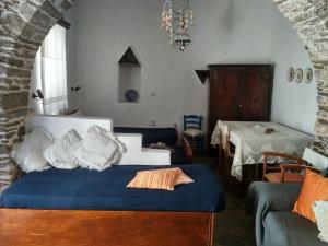 Unique traditional house dating from 1700 في Kástron: غرفة بسرير واريكة وطاولة
