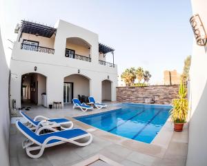a villa with a swimming pool and lounge chairs at Royal Home Luxor Pool View in Luxor