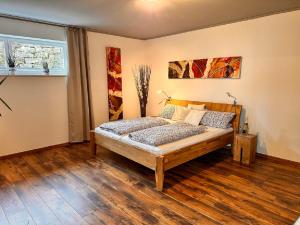 a bedroom with a bed in a room with wooden floors at Ferienwohnung Familie Nachtmann in Beilngries