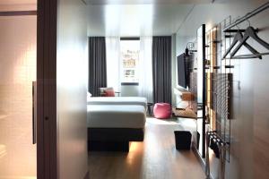 a hotel room with a bed and a window at Moxy Athens City in Athens