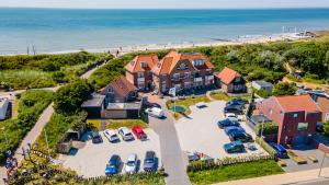 een luchtzicht op een huis met veel geparkeerde auto's bij Duinhotel Haga in Zoutelande