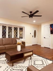 a living room with a couch and a ceiling fan at Newly renovated charming home with parking in Fort Washington