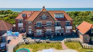 an aerial view of a house with the ocean in the background at Duinhotel Haga in Zoutelande