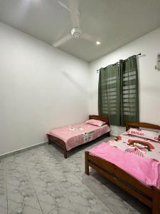 2 camas en una habitación con en Sara Homestay 1 & Sara Homestay 2, en Marang
