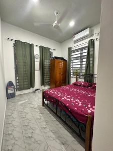 1 dormitorio con 1 cama con manta roja en Sara Homestay 1 & Sara Homestay 2, en Marang