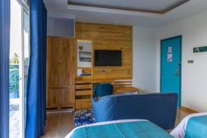 Surf House by Konalle في Gaafu Dhaalu Atoll: غرفة فندقية بسريرين وتلفزيون