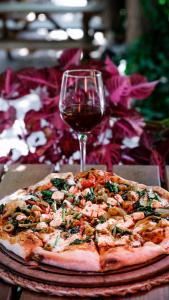 a pizza on a table with a glass of wine at Sheriff, Olympos in Kumluca