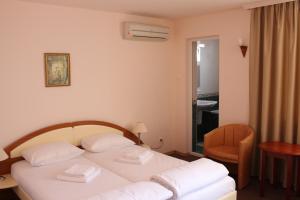 um quarto de hotel com uma cama e uma cadeira em Arlanda em Sveti Vlas