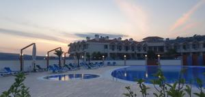un hôtel avec une piscine en face d'un bâtiment dans l'établissement Flora Hotel, à Gelibolu