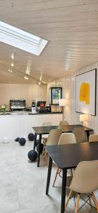 Dobre Smaki Apartaments Chill and Food في ساربينوفو: غرفة بها طاولات وكراسي ومطبخ
