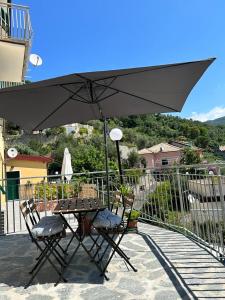 einen Tisch und zwei Stühle unter einem Sonnenschirm auf einer Terrasse in der Unterkunft Da Pippo in Moneglia