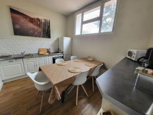 a kitchen with a table and chairs in a room at Le P’tit Nid in Parthenay