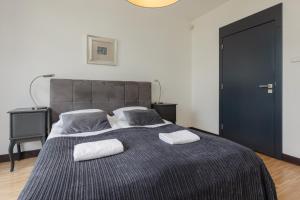 sypialnia z dużym łóżkiem z dwoma ręcznikami w obiekcie Royal Park Łazienki Apartment Warsaw Mokotów by Renters w Warszawie