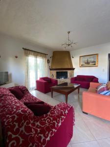 a living room with red furniture and a fireplace at Fairy House in Petrokefálion