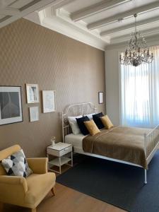 1 dormitorio con 1 cama, 1 silla y 1 lámpara de araña en Appartement Downtown, en Haarlem