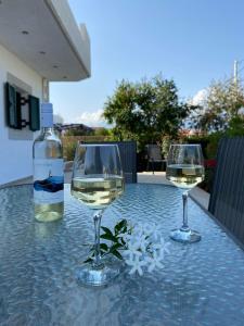 two glasses of white wine and a bottle on a table at Fairy House in Petrokefálion