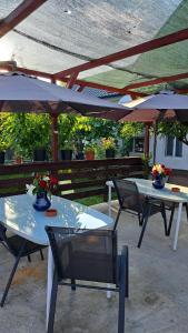 2 mesas con sillas y sombrillas en un patio en Casa Gabi, en Corbu