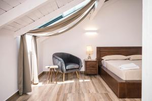 um quarto com uma cama, uma cadeira e uma janela em MASHTRA - The Olive House em Ulcinj