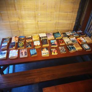 un montón de libros sentados en una mesa en Good Vibes Bungalows en Gili Trawangan