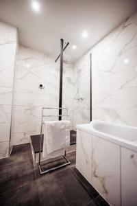 Baño blanco con bañera y lavamanos en Appartement - Centre Ville - Autoroute à 5 minutes Chez William, en Clermont-Ferrand