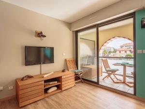 ein Wohnzimmer mit einem TV und einem Balkon in der Unterkunft Studio Hendaye, 1 pièce, 4 personnes - FR-1-2-431 in Hendaye