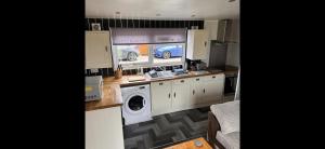 a kitchen with a sink and a washing machine at D5 Rickardos Holiday Lets in Mablethorpe