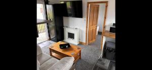 a living room with a couch and a table and a tv at D5 Rickardos Holiday Lets in Mablethorpe