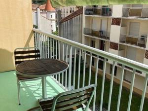 a balcony with a table and a chair and a building at Studio lumineux avec balcon, proche centre-ville et cures, parking inclus, idéal pour 2 personnes - FR-1-703-155 in Amélie-les-Bains-Palalda