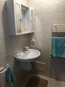een badkamer met een wastafel, een spiegel en blauwe handdoeken bij Casa La Noria in Mola di Bari