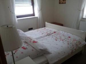 バイロイトにあるFerienwohnung Dörflerのベッドルーム1室(花が咲く白いベッド1台付)